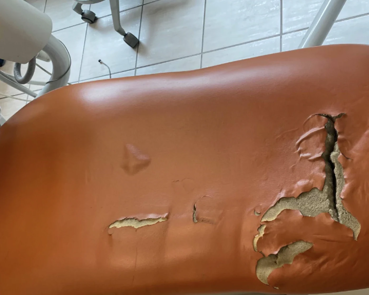 Dental patient chair with torn upholstery before restoration